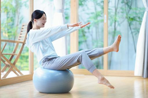 片足を曲げバランスボールに座る女性 女性,バランスボール,座るの写真素材