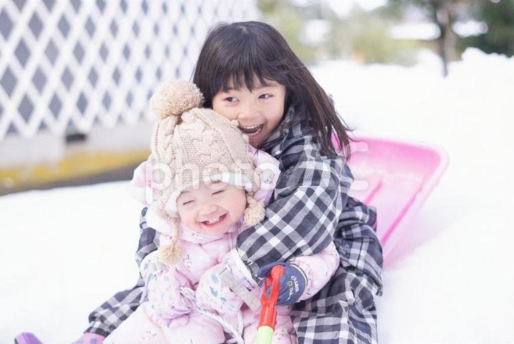 ソリ遊びを楽しむ2人 雪遊び,雪,子供の写真素材