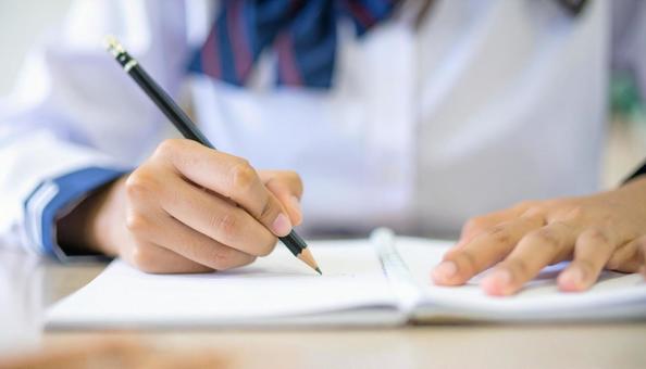 ノートに記入する日本人中学生の女の子の手 ノートに記入する日本人中学生の女の子の手の写真