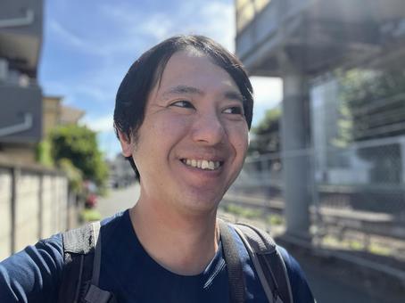 街を歩く笑顔の男性　2 歩く,日差し,暑いの写真素材