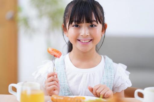 食卓でゆっくりと朝ごはんを味わう少女 女の子,食事,トマトの写真素材