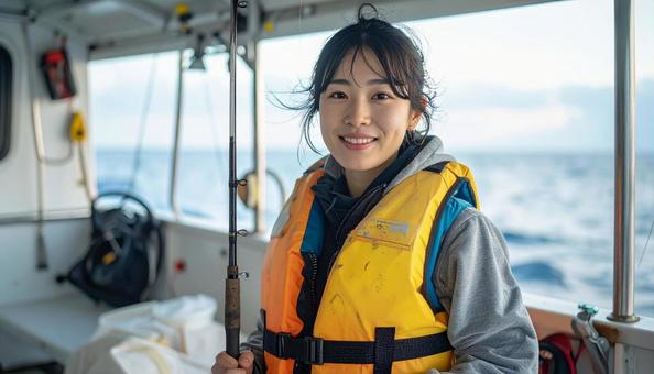 釣りを楽しむライフジャケットを着た女性 釣りを楽しむライフジャケットを着た女性の写真