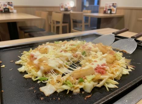 鉄板の上で湯気を立てる餅チーズもんじゃの写真