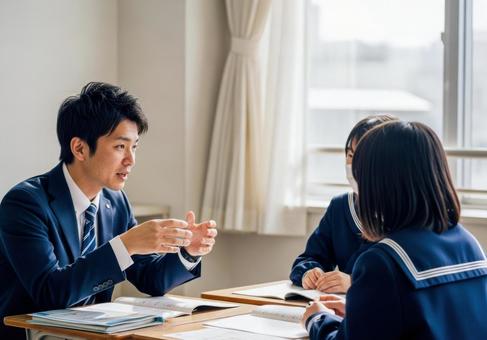 教室で生徒に指導する教師と学生の写真