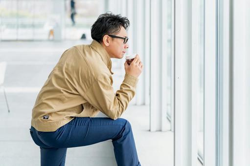 カッコつけてコーヒーを飲む作業服の男性 カッコつけてコーヒーを飲む作業服の男性 ビジネス,ビジネスマン,作業員の写真素材