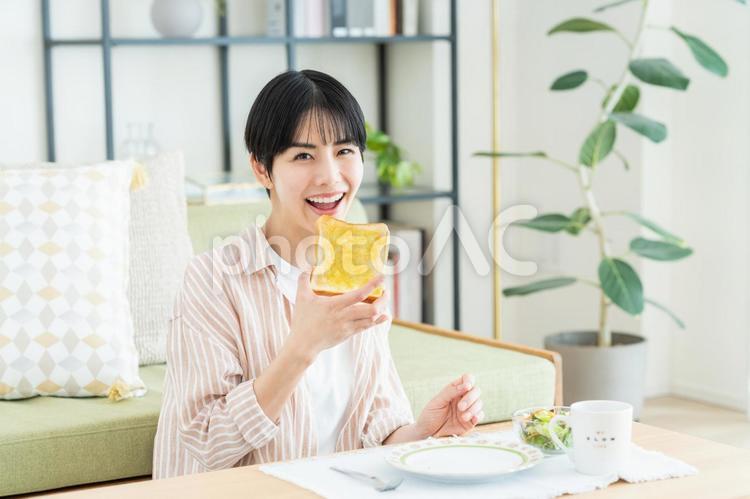 朝食でパンを食べる若い女性 パン,トースト,食べるの写真素材