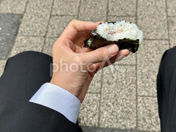 おにぎりを食べるサラリーマン サラリーマン,おにぎり,おむすびの写真素材