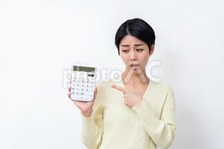 電卓を持って悩む主婦。 主婦,電卓,家計の写真素材