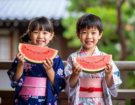 夏の縁側でスイカを食べる浴衣の子供たち 夏の縁側でスイカを食べる浴衣の子供たちの写真