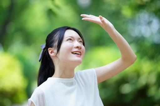 女性が公園で笑顔を見せるの写真