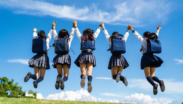 青空に向かってジャンプする生徒達の後ろ姿 青空に向かってジャンプする生徒達の後ろ姿の写真