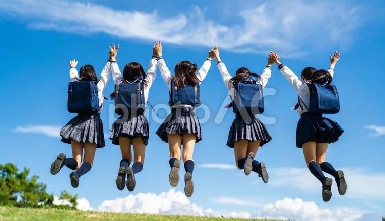 青空に向かってジャンプする生徒達の後ろ姿 青空,ジャンプ,生徒の写真素材