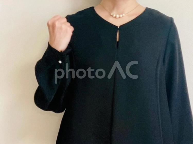 ガッツポーズをする黒いフォーマル服の女性 ガッツポーズ,女性,がんばるの写真素材