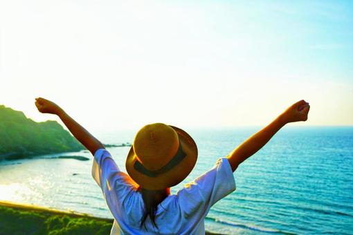 Back view of a woman taking a deep breath while looking at the sea, JPG Back view of a woman taking a deep breath while looking at the sea, JPG
