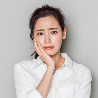 問題を抱えるような表情の女性 問題を抱えるような表情の女性の写真