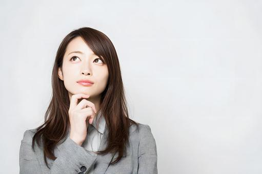 ビジネスシーンの考え込む女性。白背景 ビジネスシーンの考え込む女性。白背景の写真
