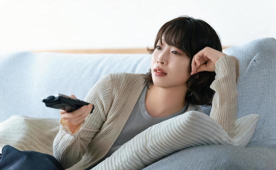 ソファでテレビを見る女性 ソファでテレビを見る女性 女性,テレビ,ソファの写真素材