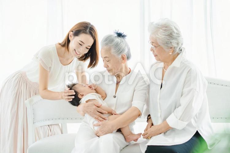 赤ちゃんを抱っこするシニア女性とお母さん  孫,おばあちゃん,シニアの写真素材