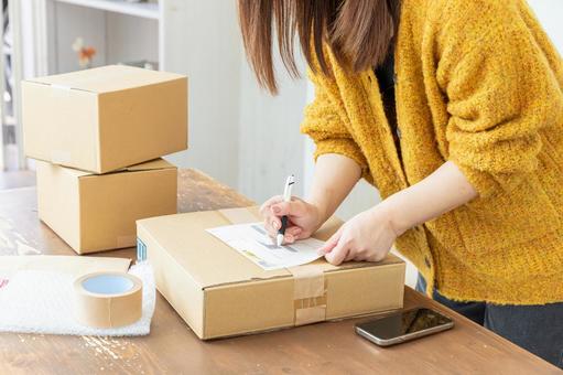 荷造りする女性の手元 荷造りする女性の手元 段ボール,荷造り,ガムテープの写真素材