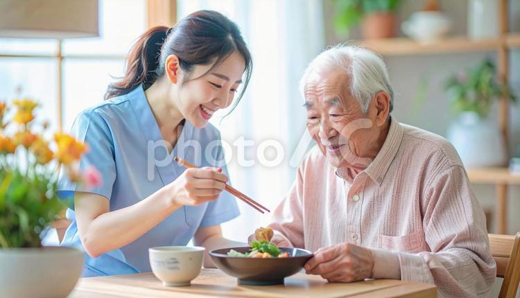 食事介助をする女性介護士と高齢男性 女性介護士,訪問介護,在宅介護の写真素材