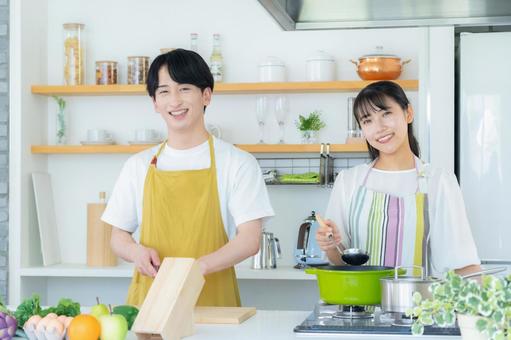 キッチンで料理を作る若い夫婦 夫婦,料理,キッチンの写真素材