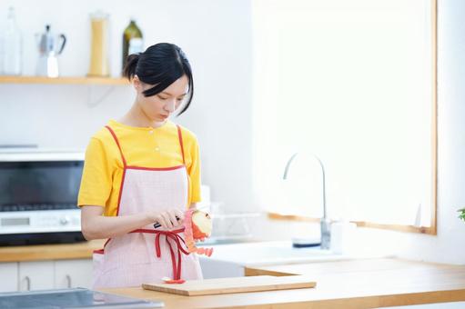 真剣な顔で皮むきをする女性 女性,真剣,リンゴの写真素材