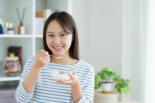 ヨーグルトを食べる若い女性 ヨーグルトを食べる若い女性の写真