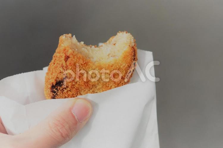 テイクアウトのコロッケ　食べかけ コロッケ,食べ歩き,食べかけの写真素材
