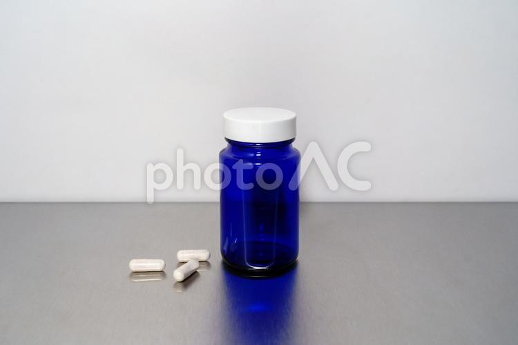 青いサプリメントボトルと白いカプセル サプリメント,ケース,薬の写真素材