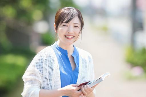 笑顔でパスポートを持つ女性 笑顔でパスポートを持つ女性 ワーキングホリデー,ワーホリ,女性の写真素材