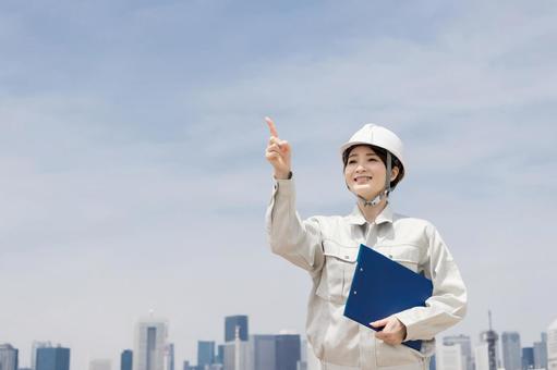 指差しをする作業着を着た女性 指差しをする作業着を着た女性 作業員,ノートパソコン,ビジネスウーマンの写真素材