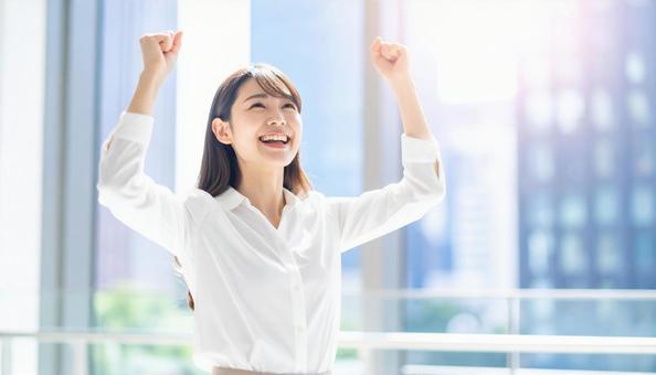 ガッツポーズで喜ぶ女性のポートレート ガッツポーズで喜ぶ女性のポートレートの写真