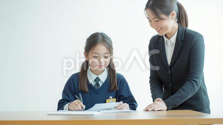 生徒の隣で勉強を教える女性の先生 先生,生徒,教えるの写真素材