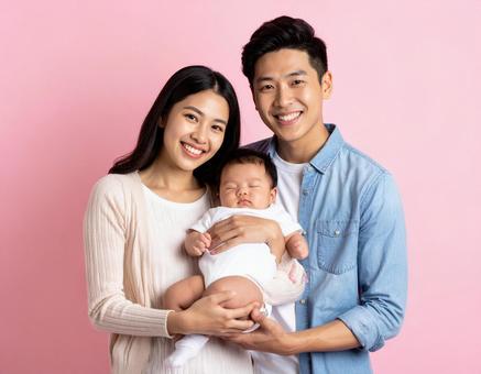 赤ちゃんを抱く幸せそうな夫婦 赤ちゃんを抱く幸せそうな夫婦の写真