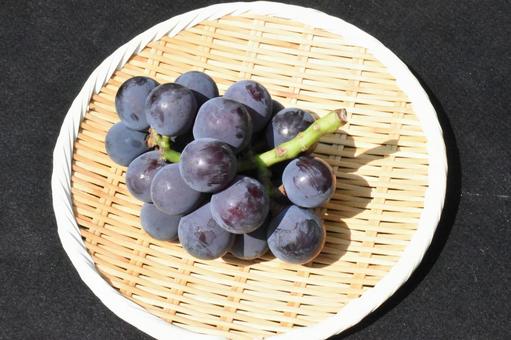 竹製の丸盆ザルに盛った浜ぶどう・藤稔 竹製の丸盆ザルに盛った浜ぶどう・藤稔の写真