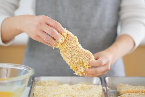 衣づけをしたとんかつを持つ手 衣づけをしたとんかつを持つ手 とんかつ,パン粉,持つの写真素材