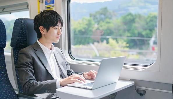 新幹線で仕事をするビジネスマンの写真
