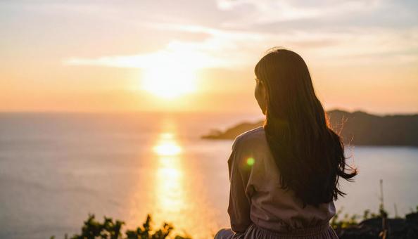 夕暮れの海と日本人の女性 夕暮れの海と日本人の女性の写真