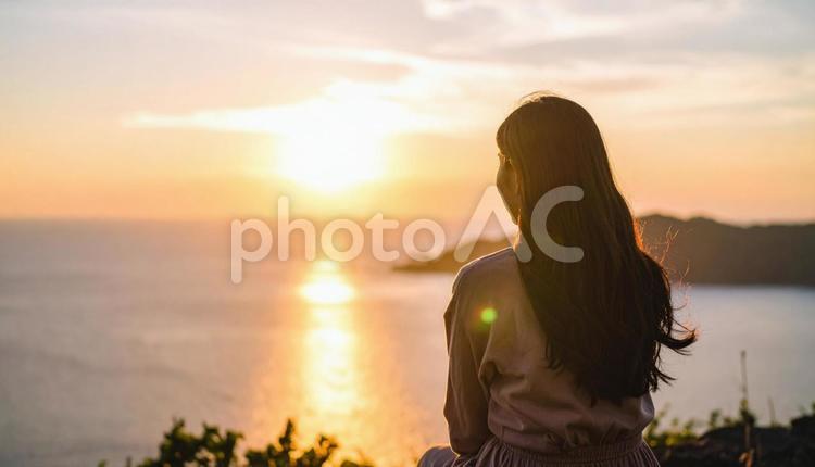 夕暮れの海と日本人の女性 夕焼け,夏,光の写真素材