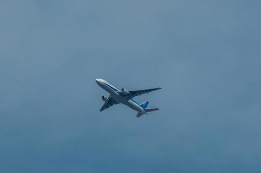 広い地平線の上を飛ぶ旅客機 広い地平線の上を飛ぶ旅客機 飛行機,航空機,旅客機の写真素材