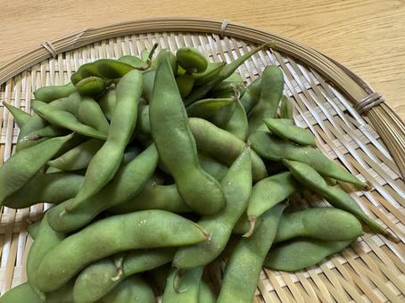 アップで見る枝豆ざる盛りと木のテーブル アップで見る枝豆ざる盛りと木のテーブル 枝豆,えだまめ,アップの写真素材