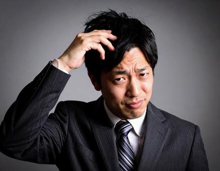 悩むビジネスマン 悩むビジネスマンの写真