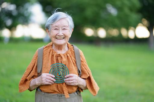 カメラ目線で蚊取り線香を持つ高齢者 女性,笑顔,蚊取り線香の写真素材