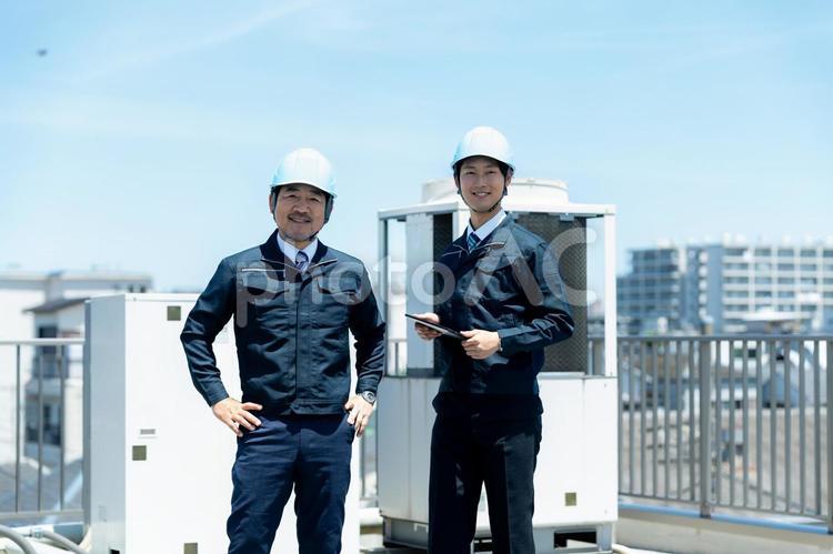 現場で打ち合わせする作業服のビジネスマン 現場で打ち合わせする作業服のビジネスマン 作業服,打ち合わせ,ヘルメットの写真素材