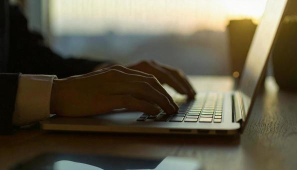 デスクワーク　パソコンに両手で入力する手の写真