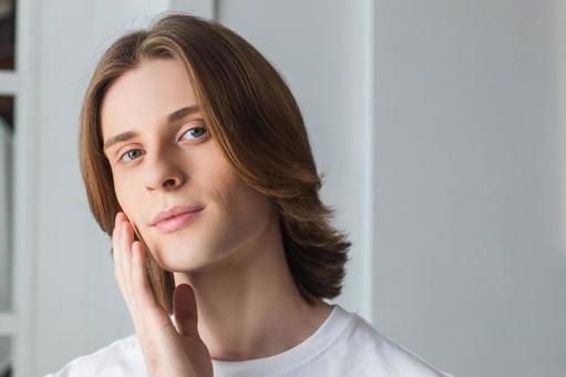 頬に手をやるカメラ目線の男性 男性,外国人,欧米人の写真素材