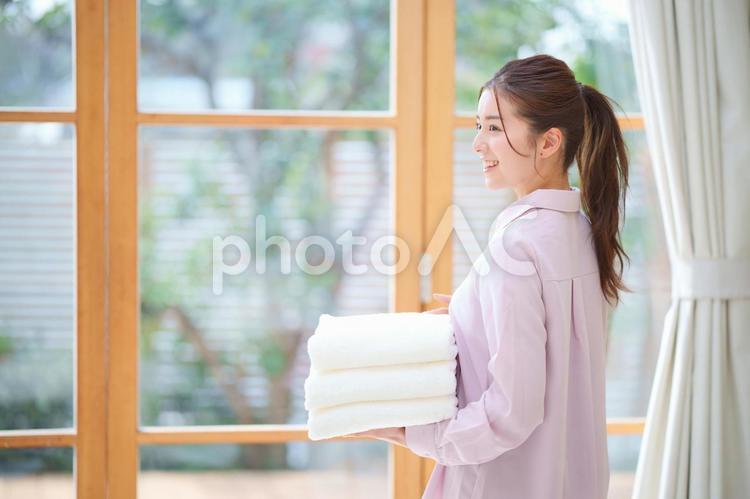 畳んだタオルを持っている女性 女性,日本人,大人の写真素材