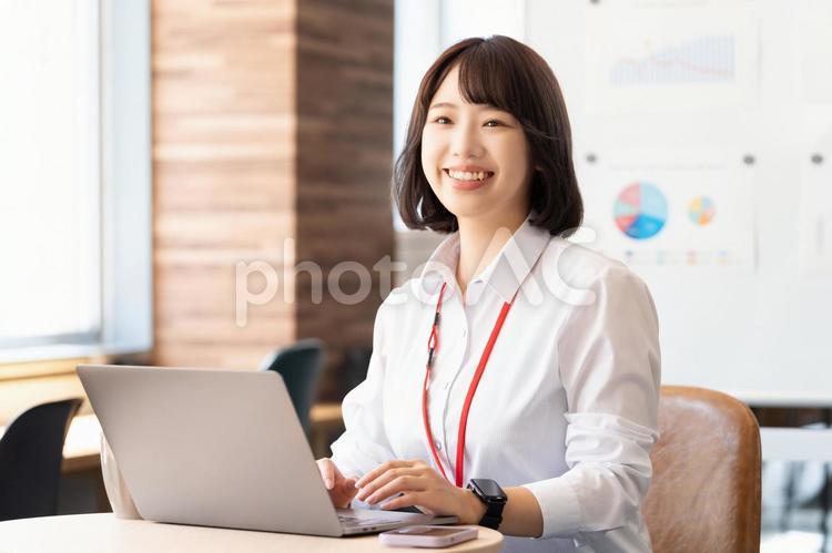 デスクワークをする若いビジネスウーマン 女性,ビジネス,笑顔の写真素材