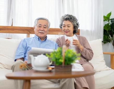 リビングでくつろぐ老後の老夫婦 リビングでくつろぐ老後の老夫婦の写真