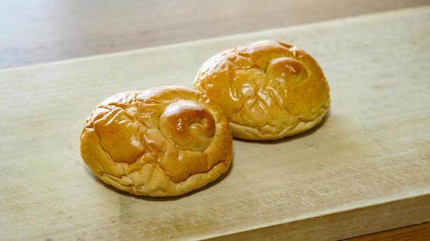 木のまな板に置かれた2つのロールパン パン,ロールパン,菓子パンの写真素材